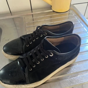 Lanvins storlek uk 9 - Säljer ett par svarta lanvins med snygg kontrast mellan mocka och lackad tå. Skorna har snörning, rund tå och vit sula. Perfekta för dig som gillar en stilren men ändå unik look. Passar till det mesta och är riktigt bekväma. Har inte använt dem regelbundet och inte alls mycket överlag därför säljer jag dom nu. 