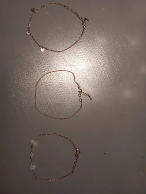 3 st fotlänkar. - 3 st fotlänkar från H&M i färgen guld med olika designer. Andvänd en del men fortfarande  fint skick. Kan även användas som armband.
