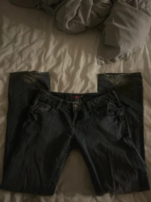 Grå/blå lågmidjade jeans från Reserved - Säljer ett par lågmidjade, något utsvängda jeans från Reserved, tillverkade i 100% denim. Färgen är en fin grå/blå färg. 