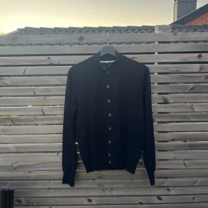 Mörkblå cardigan från Stenströms passar S - Snygg mörkblå kofta från Stenströms med klassisk passform. Tröjan har långa ärmar, knappar och gjord av merinoull. Perfekt för lager-på-lager och stilrena outfits.