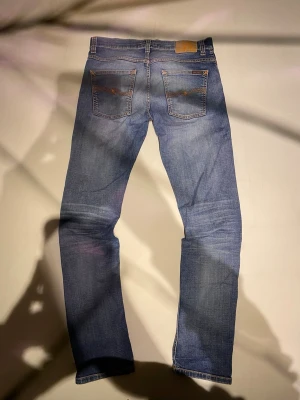 Nudie Jeans Grim Tim blå 32/34 Worn in broken - Säljer ett par Nudie Jeans Grim Tim i tvätten Worn In Broken. De är blå med snygga slitningar och klassiska orangea sömmar. Det är lagat på framsidan och i en av fickorna. Skriv om du har frågor!