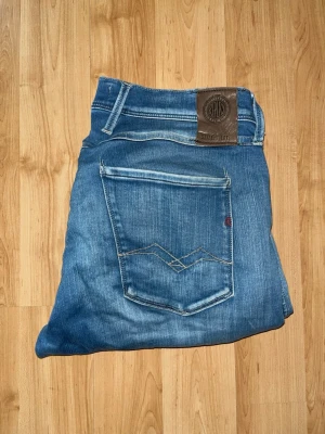 Replay Hyperflex jeans - Säljer ett par Replay Hyperflex jeans i blå tvätt med snygga slitningar och raka ben. Midja 41cm, längd 103cm. OBS jeansen har olika defekter, slitning vid skrevet, två fläckar, ena vid höger lår och längst ned vid benet - se närmare bild. JAG SKICKAR EJ FLER BILDER NÄR JAG BÄR JEANSEN! för bättre inblick i passformen rekommenderar jag att googla på modellnamnet. För storleksguide kolla måtten noggrant då jeansen alltid kan vara uppsydda heller krympta och jag ej tar emot returer :) s5,4