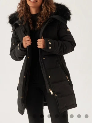 Svart Hollies jacka med päls, oanvänd - Säljer denna Hollies jacka i storlek S eftersom jag köpt en annan som jag istället ska behålla. Jackan är oanvänd och har en avtagbar svart päls. Nypris 5000kr