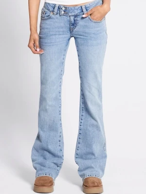 Bootcut ljusblå jeans med broderi - Säljer ett par ljusblå bootcut jeans med snyggt broderi på bakfickorna. Jeansen har låg midja och klassisk femficksdesign. Tillverkade i mjukt jeansmaterial som ger en avslappnad och trendig look.