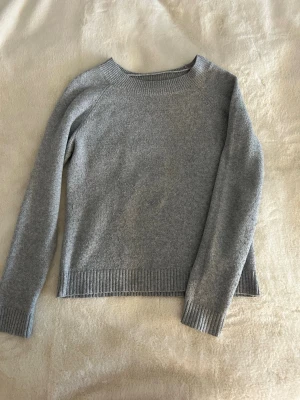 Grå stickad tröja från Vero Moda - Mysig grå stickad tröja från Vero Moda i storlek XS. Tröjan har rund hals, ribbade muddar vid ärmslut och nederkant samt långärmad passform. Perfekt för kyliga dagar och enkel att matcha med jeans eller kjol. Är nopprig kan ses på sista bilden, därför ett lägre pris!