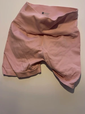 Rosa high waist cykelshorts XS - Säljer ett par ljusrosa cykelshorts från Aim'n i storlek XS. De är högmidjade med bred linning och har en scrunch-detalj bak. Materialet är mjukt och stretchigt, perfekt för träning eller chill. Snygg passform som sitter på plats.