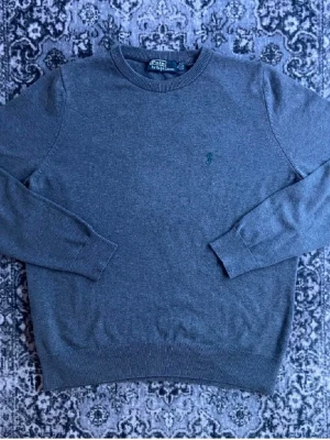 Grå tröja från Polo Ralph Lauren - Snygg grå tröja från Polo Ralph Lauren i 100% bomull. Storlek M. Har tyvärr inget kvitto eller äkthetsbevis därav de väldigt låga priset.