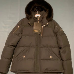 Moose Knuckles Q3 Jacka - Marinblå - Svart päls, storlek XL. Prislapp sitter kvar, säljes pga ångrat köp från Johnells. Du får även med galgen :) 5 999 kr - priset kan diskuteras!