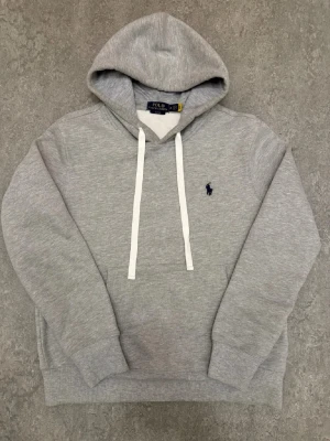 Ralph Lauren hoodie - Säljer denna tvär feta ralph lauren hoodie. Den är grå med dom klassiska vita snörena, storlek S och är i toppskick. Hör av er vid frågor.