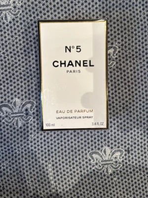 Chanel N°5 Eau de Parfum 100ml - Chanel N°5 Eau de Parfum 100ml är en ikonisk doft från Paris. Innehåller bl.a. alkohol, aqua (vatten), parfym (fragrance), benzyl alcohol, citronellol och limonene. Tillverkad i Frankrike. Perfekt för dig som vill ha en klassisk touch i din stil.