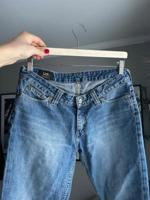 Blå Lee straight jeans - Säljer ett par klassiska blå jeans från Lee med raka ben och låg midja! Materialet är slitstarkt denim i bomull och färgen är ljusblå med snygg tvätt. Jeansstorlek är 29, längd 33