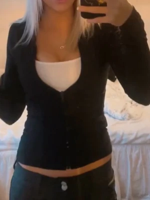 Svart sipp tröja  - Säljer en svart, figurnära sipp tröja. perfekt att styla över ett linne eller topp. Enkel och clean look som passar till det mesta.