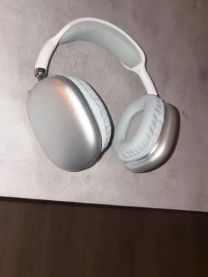 Hörlurar - Snygga AirPods Max i silver. Over-ear hörlurar med aktiv brusreducering och hög ljudkvalitet. Skicket ser mycket bra ut utan synligt slitage eller repor. Perfekt för musik, film och samtal med lång batteritid och bekväm passform.