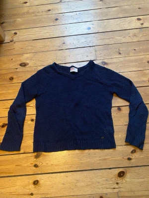 Mörkblå stickad tröja  - Mörkblå stickad tröja med rund halsringning och långärmad modell. Tröjan har ett diskret strukturmönster och ribbade muddar vid ärmslut och nederkant. Perfekt till lager på lager under höst och vinter. Priset kan diskuteras. Skriv vid frågor😊