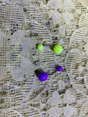 Färgglada navelpiercings  - Säljer ett mixat set med fyra navelpiercings i plast och metall. Kulorna är i neonfärger som lila, orange, grå, rosa och gul, vissa med ränder eller mönster. Perfekt för dig som vill ha något lekfullt och unikt till din piercing. 50kr/2st /bild 