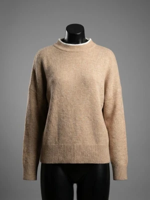 Beige stickad tröja från H&M - Mysig beige stickad tröja från H&M i storlek L. Tröjan har en rund halsringning, ribbade muddar vid ärmslut och nederkant samt långärmad passform. Perfekt för lager-på-lager under kyliga dagar.