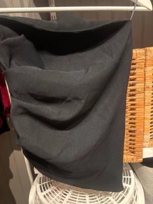 En svart topp från Zara - Säljer en svart topp  från Zapa med snygg draperad effekt framtill. Toppen  har en enkel, stilren look och är gjord i ett mjukt, följsamt material som ger en smickrande passform. 