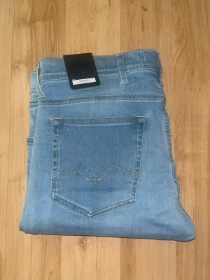 Replay Jondrill jeans - Helt nya! Säljer ett par Replay Jondrill jeans i ljusblå tvätt. Jeansen är tillverkade i power stretch denim och har en slim passform. Midja 42cm, längd 100cm. JAG SKICKAR EJ FLER BILDER NÄR JAG BÄR JEANSEN! för bättre inblick i passformen rekommenderar jag att googla på modellnamnet. För storleksguide kolla måtten noggrant då jeansen alltid kan vara uppsydda heller krympta och jag ej tar emot returer :) 1,29