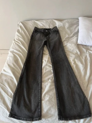 Svarta bootcut jeans med fina fickor  - Säljer ett par svarta bootcut jeans med snyggt vitt broderi på bakfickorna.Perfekta för dig som vill sticka ut med detaljerade fickor.