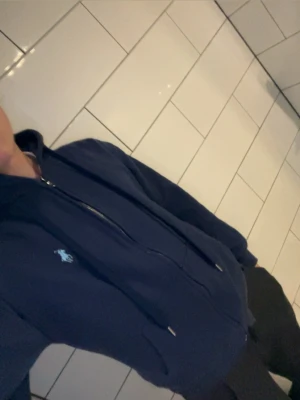 Mörkblå Zip Hoodie från Polo Ralph Lauren - En snygg stilren tröja från Ralph Lauren, funkar till många olika stilar och är perfekt nu till vintern/våren, ett måste i din garderob. Priset går att diskutera skriv vid minsta fundering🤝 Nästan aldrig använd då den är för liten för mig.