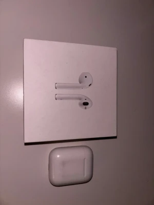 Apple AirPods (2nd Generation) ”ÄKTA” - Säljer ett par Apple AirPods (2nd Gen) med originalförpackning och laddningsetui. Hörlurarna är fullt fungerande men etuiet visar tecken på användning och har viss smuts invändigt. Perfekt för dig som vill ha trådlös frihet och bra ljudkvalitet. Ända problemet är att man behöver koppla dom varje gång man ska använda dom men det är inte illa.