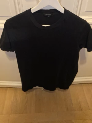 Svart t-shirt från Paul & Friends - En klassisk svart t-shirt från Paul & Friends i enkel design. T-shirten har rund halsringning och korta ärmar. Perfekt basplagg att matcha med allt. Tillverkad i mjuk bomull för skön känsla.