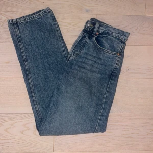 Blå raka jeans från Zara, strl 36 - Säljer ett par klassiska blå jeans från Zara i rak modell. Jeansen har fem fickor, normal midja och snygg tvättad finish. Passar perfekt till en avslappnad look och är tillverkade i slitstarkt bomullsjeansmaterial.