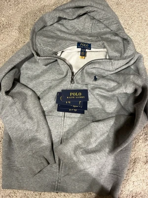 Polo Ralph lauren zip hoodie - Ralph lauren zip hoodie som är nyköpt, den har varit använd men prislappen finns kvar. Nypris ca 1250kr. Passar ungdomar i åldrarna 14-16