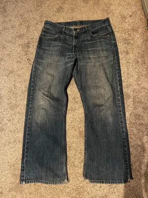 Levis 527 bootcut - Levis 527 bootcut i storlek 33/28. Dom är väldigt slitna vid hälarna men de ger en najs look. Längd-96cm, midja-42cm. Skriv om frågor finns!