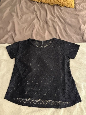 Svart spetsblus från H&M - Säljer en svart blus från H&M i storlek S. Snygg och luftig känsla, passar till många olika outfits.