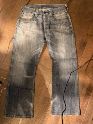 Levi's 512 - Säljer ett par klassiska Levi's 512 jeans i ljusblå tvätt med slitningar och råa detaljer vid benslut. Jeansen har rak passform, fem fickor och normal midja. Säljer ännu igen för att jag har växt ur stilen.😓 tyckte dessa va skit feta, å jag hoppas den nästa som köper inte blir besviken. Vid frågor skriv!😇