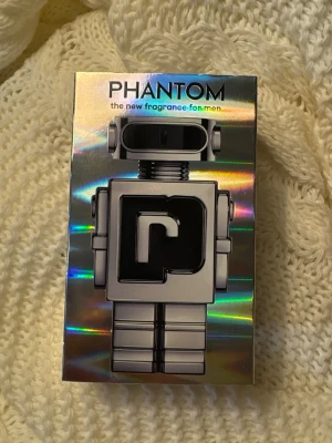 Phantom EdT 100ml robotflaska - Phantom från Paco Rabanne i en futuristisk robotflaska. Eau de toilette, 100 ml. Tillverkad i Frankrike. Ingredienser: alkohol denat., parfum, aqua, limonene, linalool, citronellol, geraniol, m.fl. Perfekt för dig som vill sticka ut med en unik design.