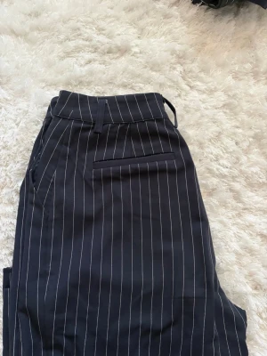 Blå randiga kostymbyxor  - Marinblå/vit randiga. Använda fåtal gånger. Mycket bra skick 