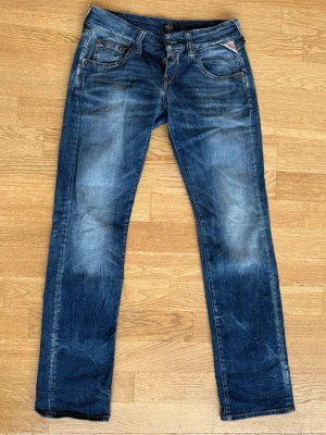 Blå Replay jeans med nitar - Säljer ett par raka, blåa Replay jeans med snygga slitningar och coola nitar på bakficka. Jeansen har en tydlig Replay-logga på fickan och är tillverkade i slitstarkt denimtyg. Strl W29 L32 och sitter som 36-38 / S ❤️