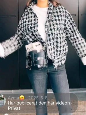 Svartvit rutig kappa med knappar - Säljer en svartvit kappa med rutigt mönster och knappar framtill. Jackan har en loose passform och är långärmad. 