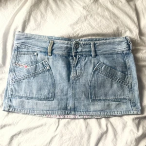 Minikjol jeans - Suuuper söt jeanskjol från diesel, perfekt till sommaren! Storleken står inte men skulle säga att den passar XS/S bäst, kanske M beroende på önskad passform! Midjemåttet är 41cm och den är 30cm lång!