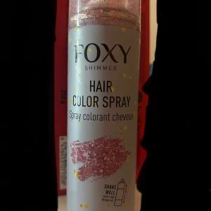 Foxy Shimmer hårfärgspray rosa glitter - Foxy Shimmer Hair Color Spray i rosa med glittereffekt. Ganska mycket kvar i den. Sprayen funkar inte så bra så man får ha sprayen väldigt nära håret eller så för sprayen rinner mest när man försöker spreja men man får komma på egna lösningar.❤️