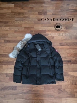 Canada Goose WyndHam Parka Red Label - ❤️ Canada Goose Wyndham Parka Red Label – Svart (L) ❤️ Exklusiv och mycket varm vinterjacka från Canada Goose i Red Label-utförande med röd emblem och stilren premiumdesign. Mycket fint skick och redo för att skickas ut! Perfekt för nordiskt klimat med tjock dunfyllning, skyddande huva och djupa dragkedjefickor. Notera tagg avklipt. En lyxig och praktisk vinterfavorit.  📦 Snabb leverans – skickas samma dag 📩 (såvida inga hindr.) Skriv vid intresse