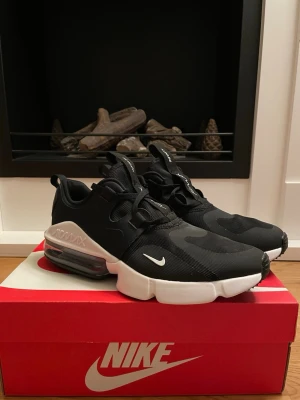 Nike Air Max Infinity - Nike Air Max Infinity sneakers i svart med vit sula och tydlig Air Max-dämpning. Skorna har snörning, mesh- och syntetmaterial samt coola detaljer som dragflikar på plösen och hälen. Swoosh-logga på sidan och textdetaljer på plösen. 