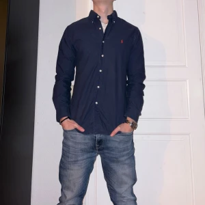 Mörkblå skjorta från Ralph Lauren - Mörkblå skjorta från Ralph Lauren i storlek M.  Fint skick till ett bra pris. Nypris: 1995kr. Mitt pris: 349kr. Vid frågor eller funderingar, tveka inte att höra av dig.