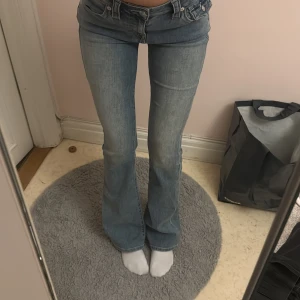 True Religion Becca Bootcut Jeans - Säljer ett par ljusblå bootcut jeans från True Religion, modell Becca Mid Rise Bootcut. 85cm innerben, midja 30 ish