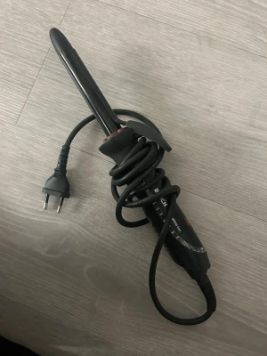 Svart locktång Bosch Quattro-Ion - Säljer en svart locktång från Bosch, modell Quattro-Ion. Den har ett smalt värmeelement, greppvänligt handtag och en röd knapp för jonfunktion. Utrustad med sladd och EU-kontakt. Perfekt för att fixa snygga lockar snabbt.