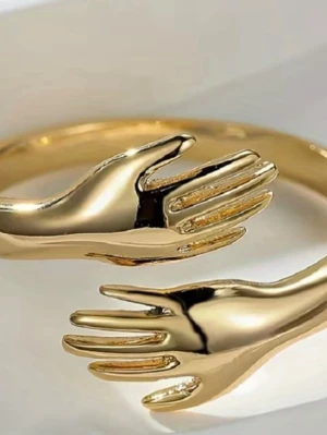 Guldfärgadring ✨ omfamnande händer | trendig statement ring - Superfin guldfärgad ring med unik hand-design som symboliserar kärlek, trygghet och connection 🤍 Öppen modell som gör den lätt justerbar i storlek. Perfekt som statement-smycke eller present 🎁 ✨ Trendig & iögonfallande ✨ Lätt att styla – passar både vardag & fest ✨ Mycket fint skick Skickas snabbt 📦 Skriv gärna om du vill ha fler bilder! 