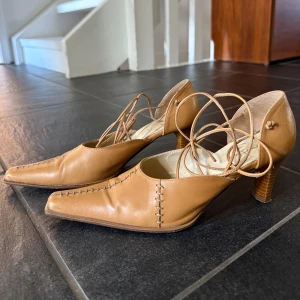 Beiga pumps med snörning - Ett par 90-tals klackar med snörning i sparsamt använt skick. Äkta läder Strl.37 fungerar även på en 38:a m smal fot.