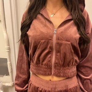 Tracksuit-set i sammet plommonfärg - Säljer detta plommonfärgade/bruna/vinröda mjukis/tracksuit set i mjuk sammet! Supersnygga! 💖 Byxorna är breda & långa (passar mig som är 180cm). Koftan är croppad & har en luva. Älskar! (Perfekt airport outfit). Använd 1 gång 💜 Fraktar/möts upp i Solna! Kolla min profil för mer kläder<3 Paketpris gäller! 