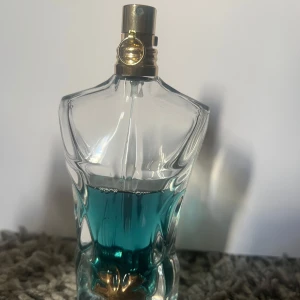 Jean paul gualtier le beau edt - Ikonisk parfymflaska formad som en torso, fylld med blått innehåll. Perfekt för dig som vill sticka ut med en klassisk och trendig doftaccessoar.