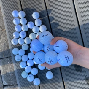 Begagnade golfbollar - blandade märken - 50 st begagnade golfbollar från kända märken som Nike, Titleist, Wilson, Srixon, Top Flite och Callaway. Bollarna är i gott skick med mindre tecken på användning. Perfekt för träning eller spel. Säljs i blandad låda, olika modeller och nummer. Du får också med några peggar! 🤩