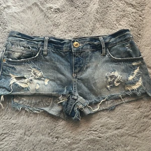 Lågmidjade jeans shorts - Skitsnygga jeans shorts med slitningar. Midjemått-41cm, grenmått-19,5cm💕🩷