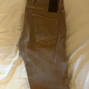 Beige Replay byxor i bomull - Snygga beige byxor från Replay med klassisk femficksdesign och diskret logga på fickan. Tillverkade i mjuk bomull, perfekta för en avslappnad och stilren look. Passar dig som gillar enkel och clean stil.