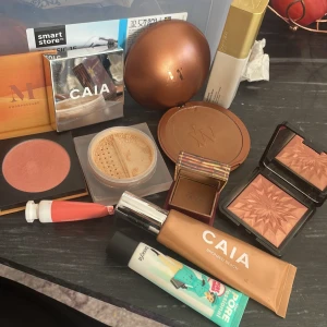 Nästan aldrig använt  - Säljer ett sminkpaket med CAIA Bronzed Beach flytande bronzer, puderbronzer och highlighter, Benefit Hoola bronzer, The POREfessional primer, BeautyAct Dewy Serum, Morphe rouge i persikoton, Douglas palett och CAIA löspuder. Färgerna går i brons, korall och nude. Dm mig för enskilda köp 